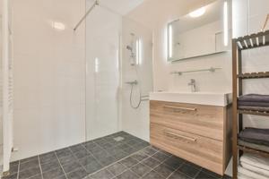 Salle de bain avec douche italienne carrelée.